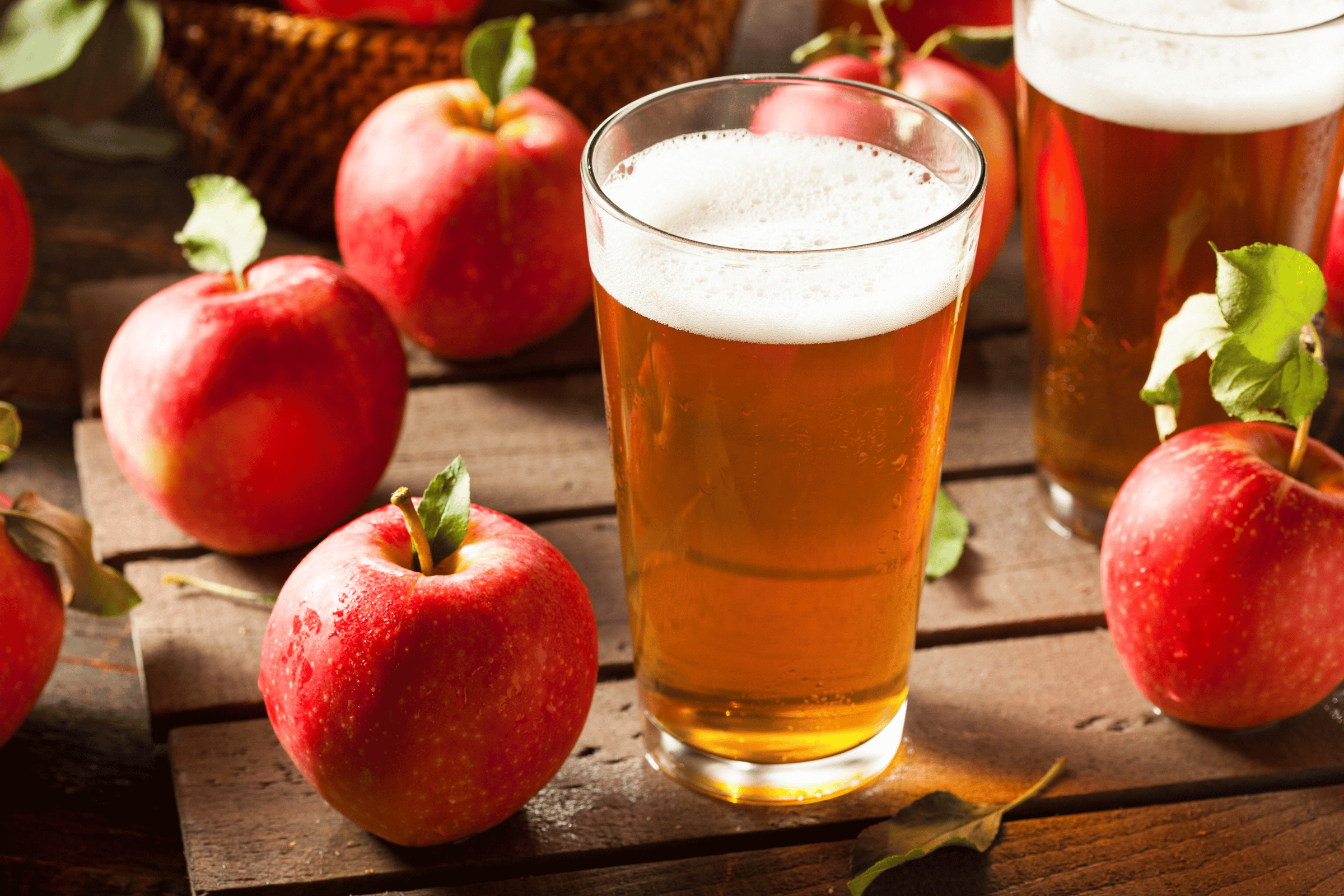 Glass of ale next to fresh apples