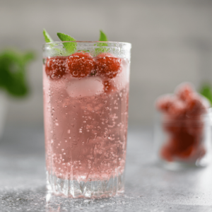 A glass of sparkling berry seltzer with fresh berry garnish. 