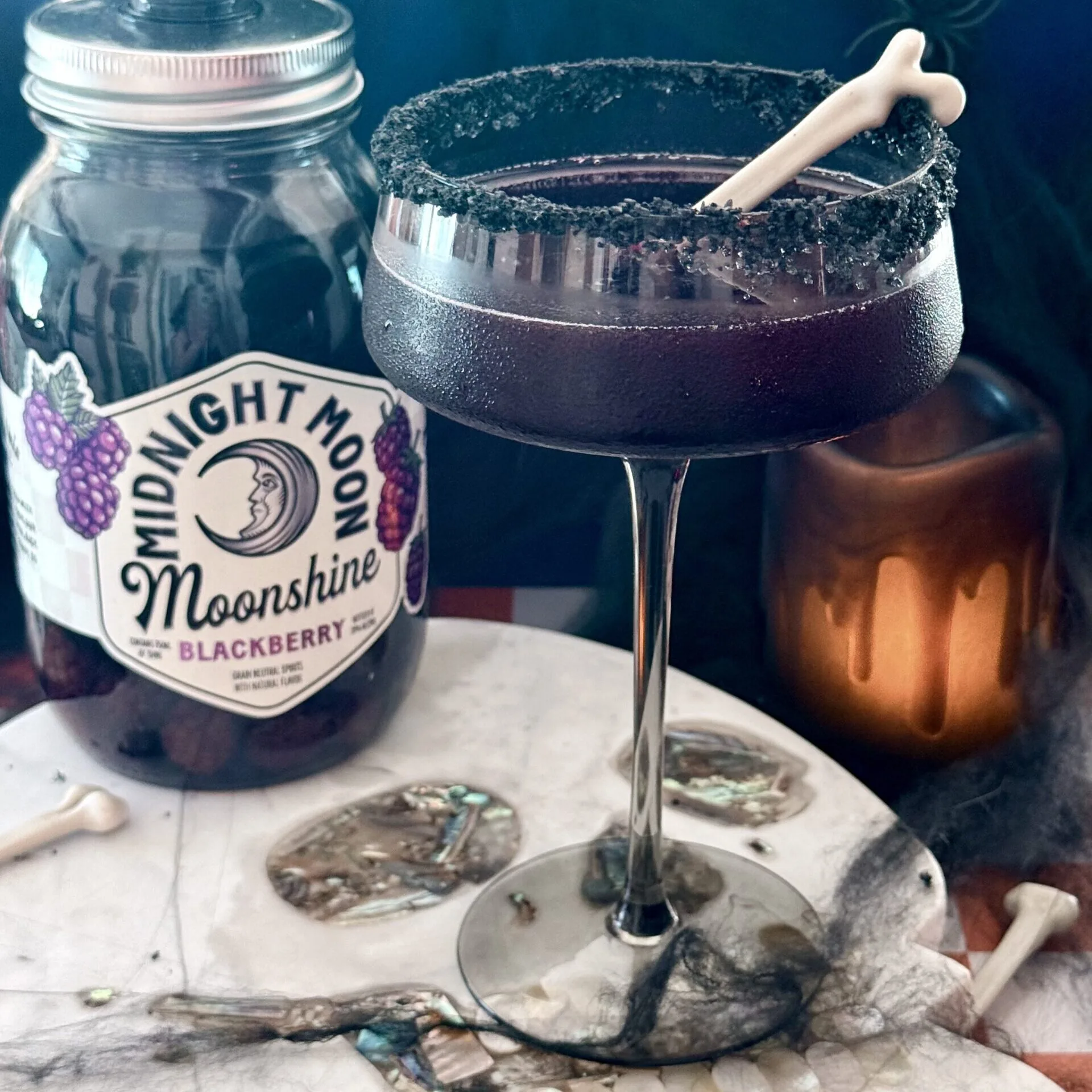 A jar of Midnight Moon Blackberry Moonshine and Black Widow Cocktail